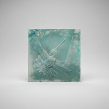 Load image into Gallery viewer, A square textured wall art piece featuring a sculpted hummingbird in light blue and white tones against a mottled teal background, photographed against a dark surface.
